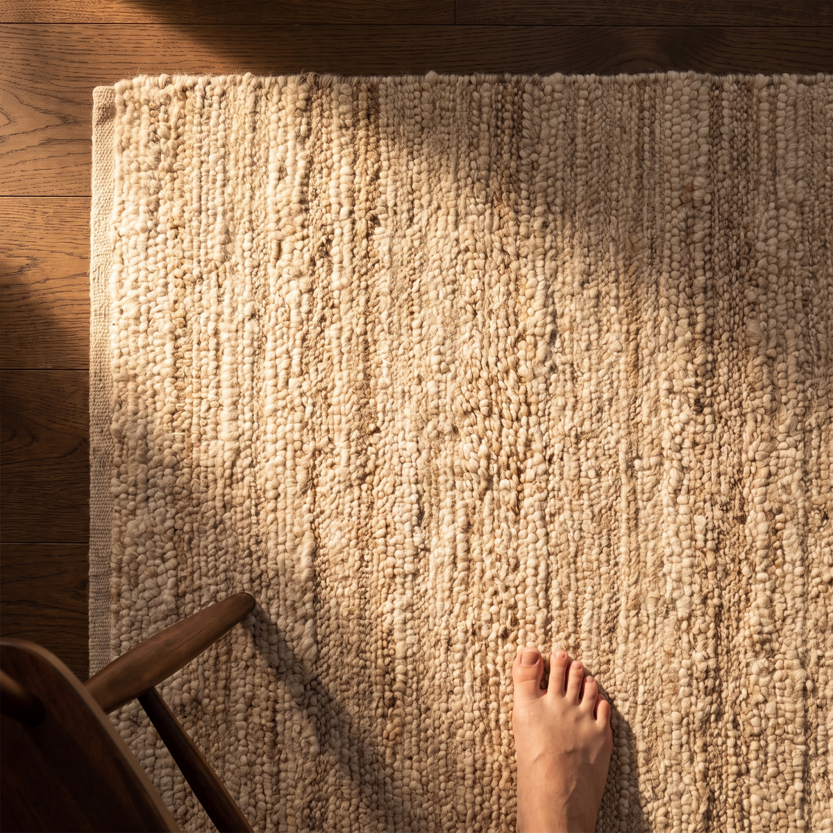 A woven rug on a wooden floor in warm daylight