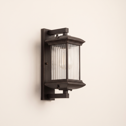 Dark bronze ribbed glass wall lantern on a plain off-white wall