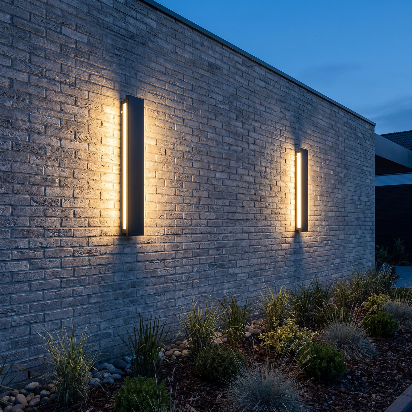 Two linear wall lights grazing a brick wall at blue hour