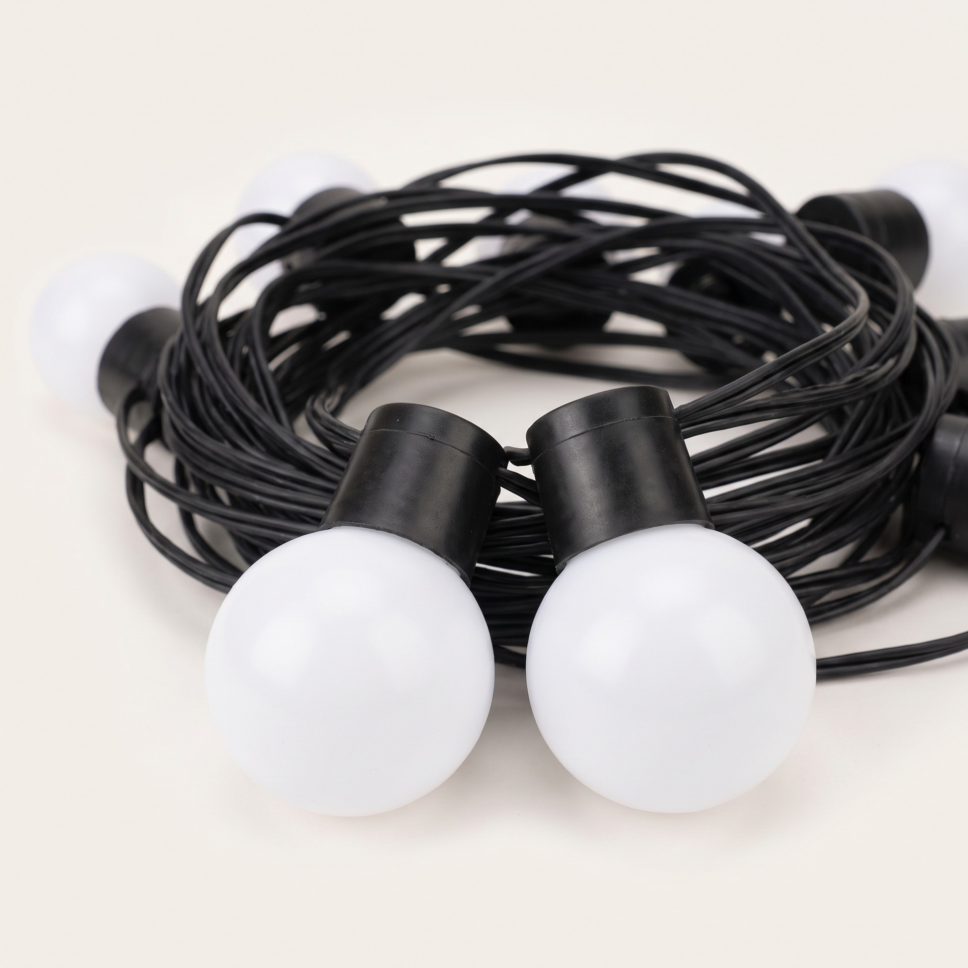 The light string coiled on a plain background, bulbs unlit