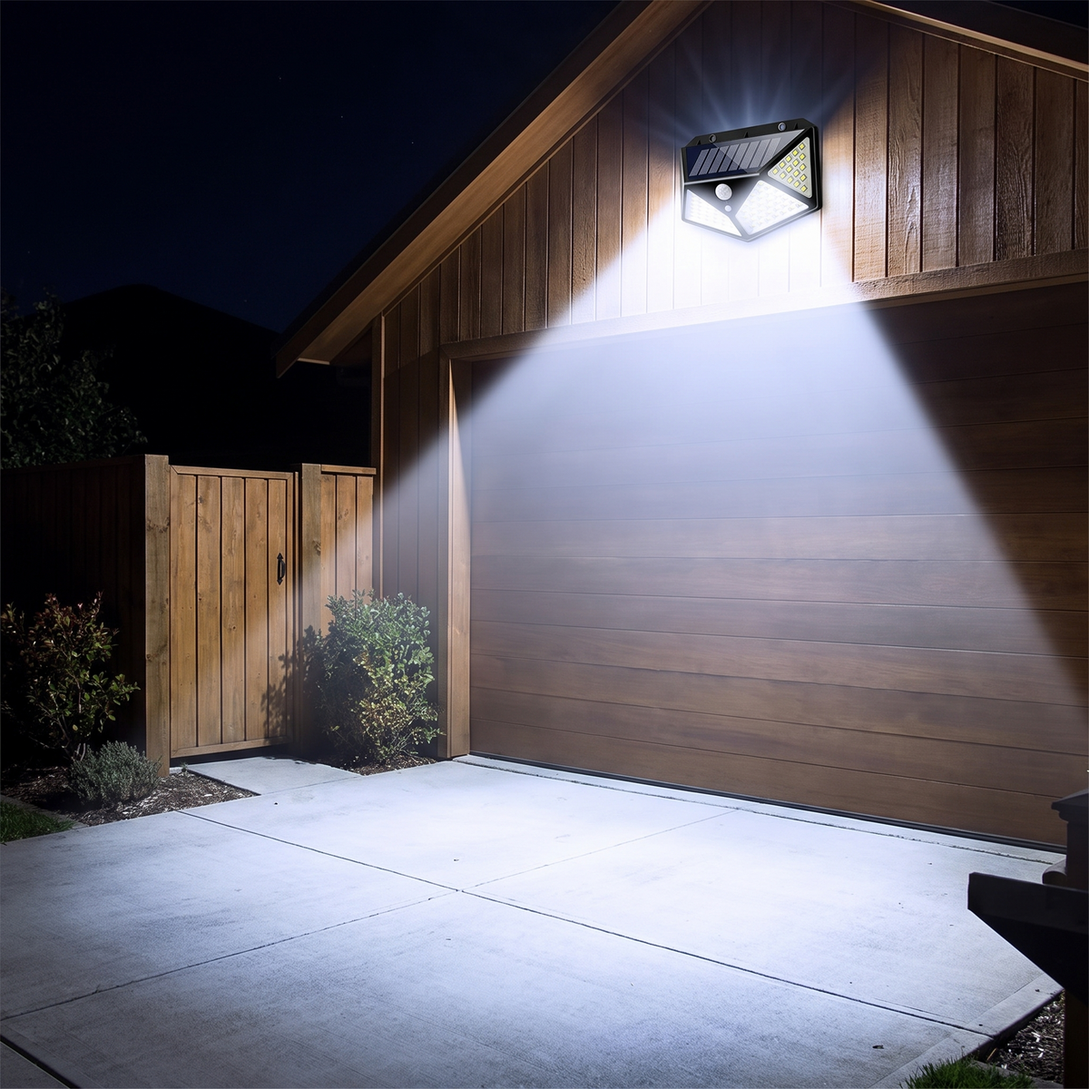 Solar motion sensor floodlight lighting a driveway at night