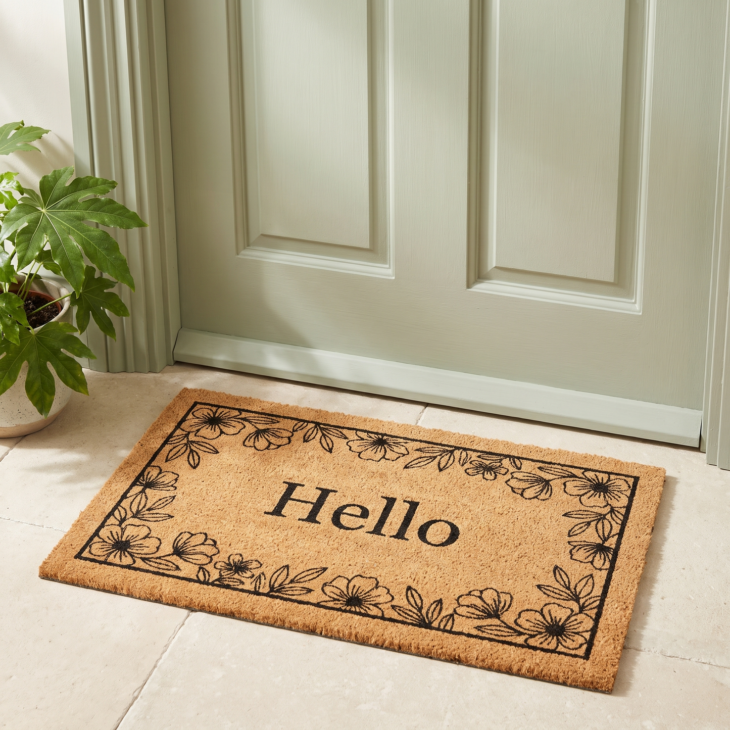 Hello Floral coir look doormat on a stone threshold in front of a sage green front door