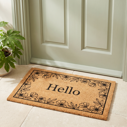 Hello Floral coir look doormat on a stone threshold in front of a sage green front door