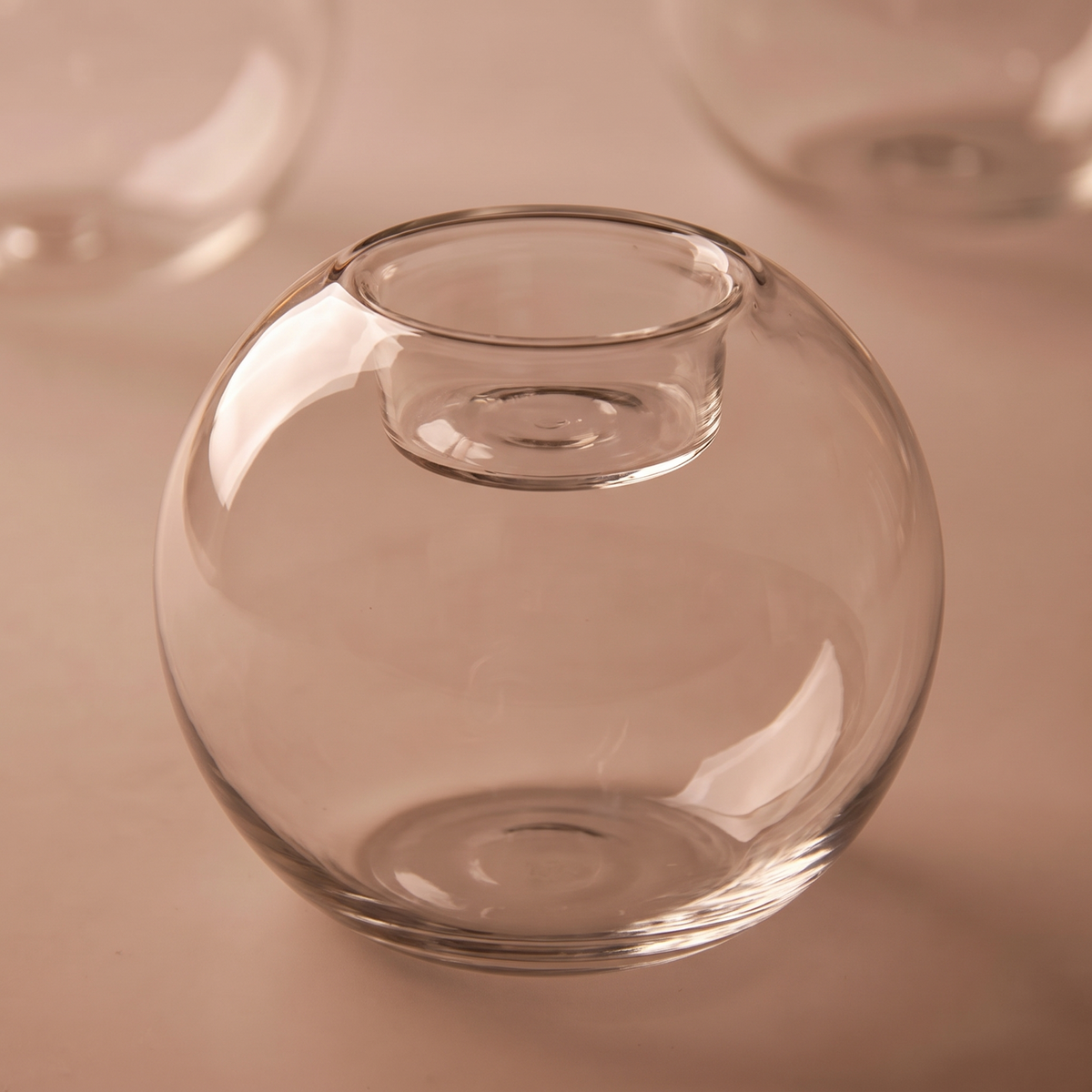 The glass globe holder unlit and empty showing its open top and flat base
