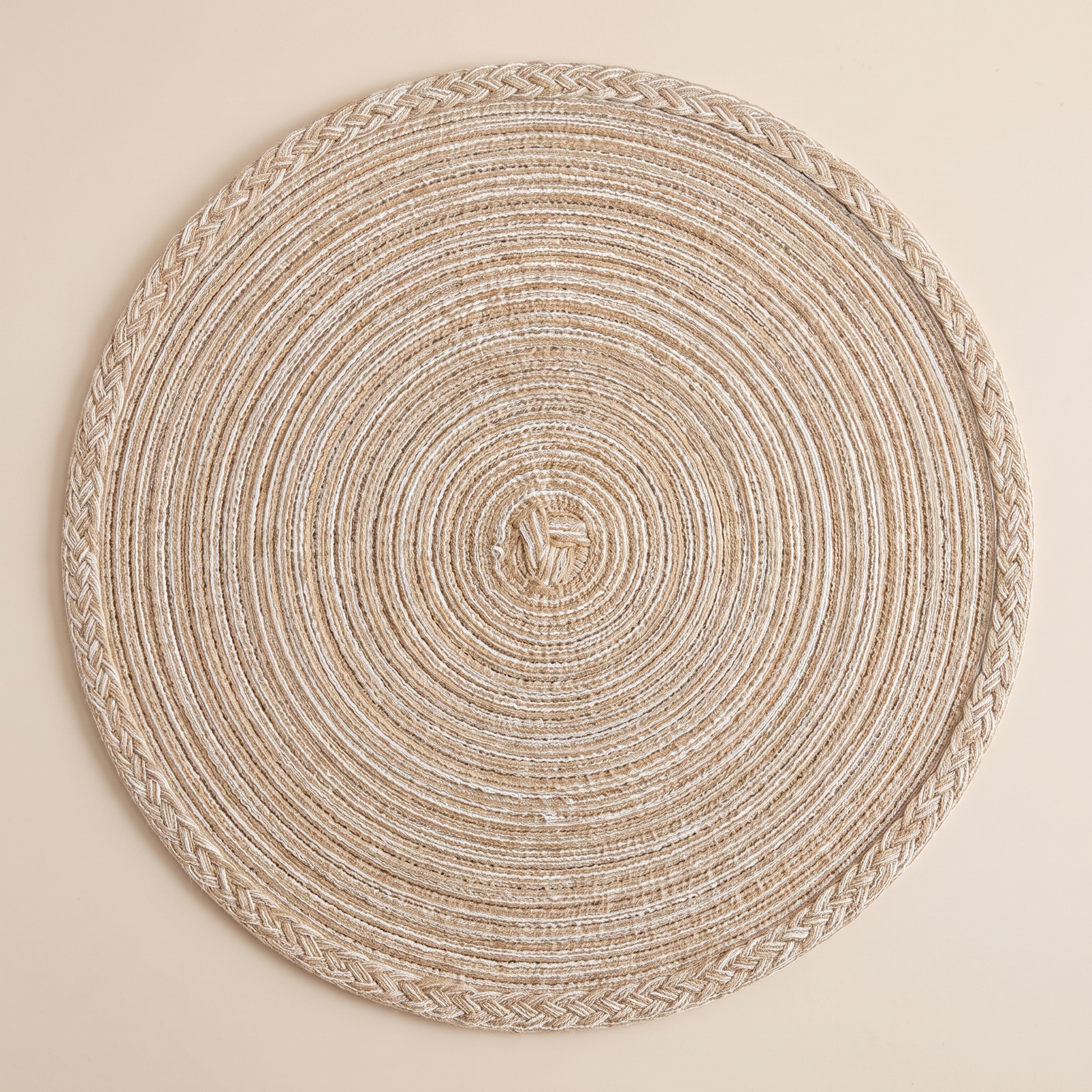 Overhead view of a single round braided placemat showing the coil