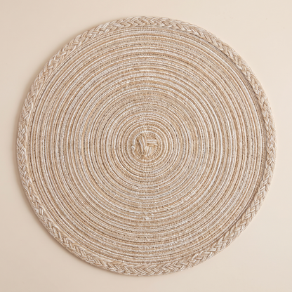 Overhead view of a single round braided placemat showing the coil
