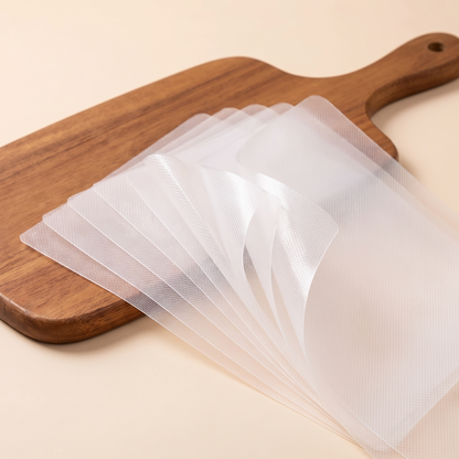 A fanned stack of thin cutting sheets beside a wooden board