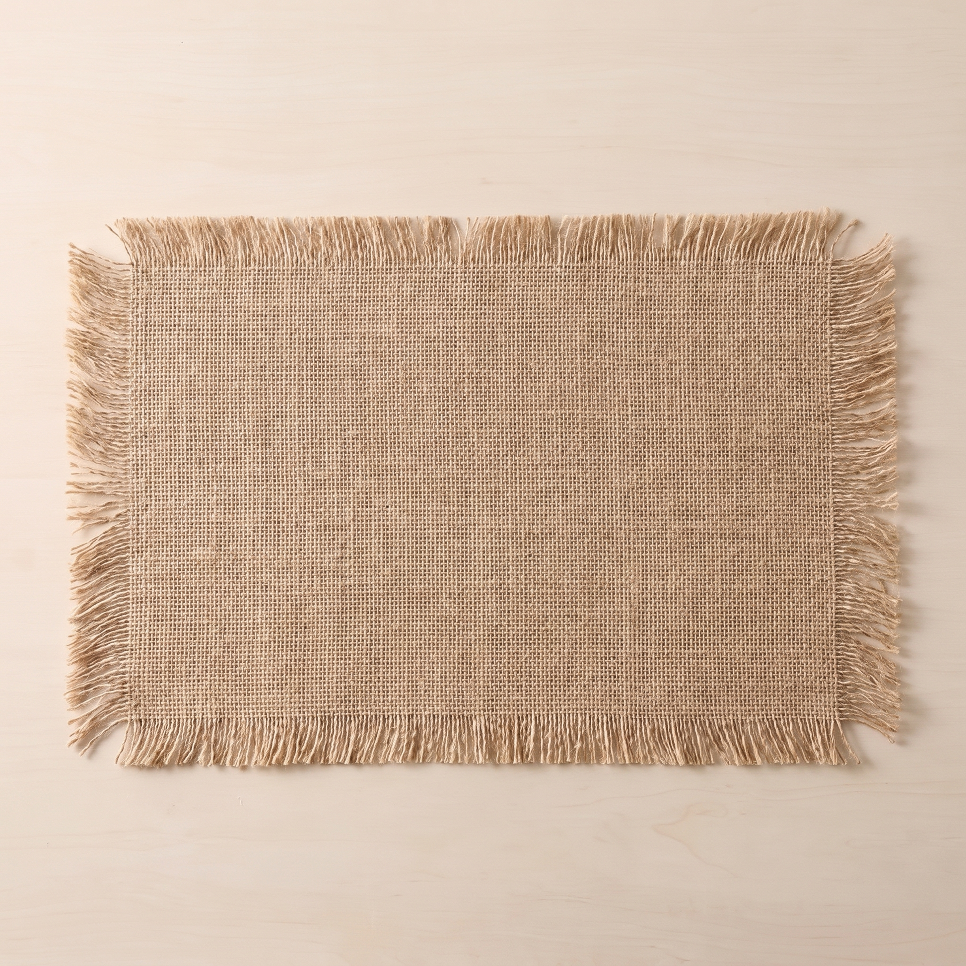 Overhead view of a single fringed jute placemat