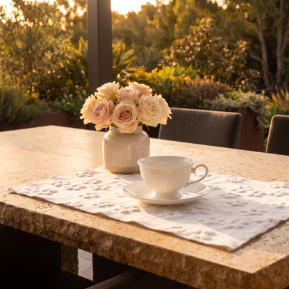 Embroidered cotton placemat on a dining table with a teacup